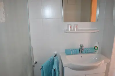 a bathroom with a sink and a mirror and blue towels at Gruberhof in Rodengo