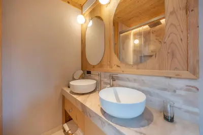 a bathroom with two sinks and a mirror at Villa Oretta in Cortina dʼAmpezzo