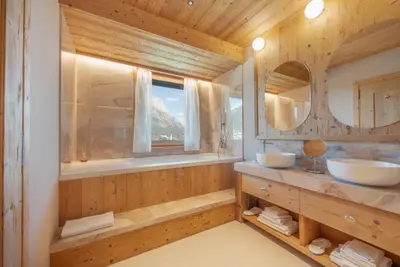 a bathroom with two sinks and a window at Villa Oretta in Cortina dʼAmpezzo