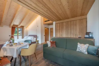 a room with a couch and a bed and a table at Villa Oretta in Cortina dʼAmpezzo