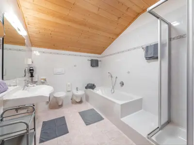 a bathroom with a tub and a sink and a toilet at Sonnenresidenz Kastelruth in Castelrotto
