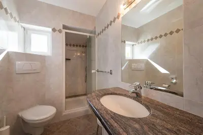 a bathroom with a sink and a toilet at Tirolerin Garni Hotel in Termeno