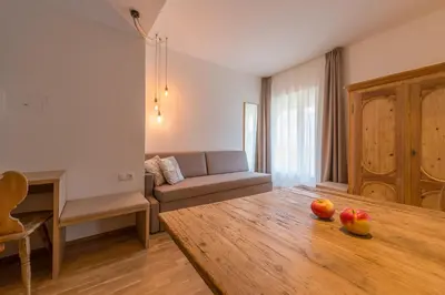 a living room with a table and a couch at Tirolerin Garni Hotel in Termeno