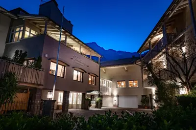 an exterior view of a house at night at Tirolerin Garni Hotel in Termeno