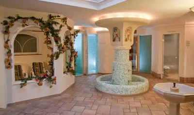 a lobby with a fountain in the middle of a room at Hotel Waldheim in Sarnonico