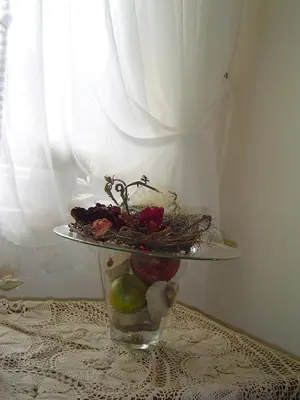 a vase with a plate of fruit on a table at Hotel Garni Hubertus in Tirolo