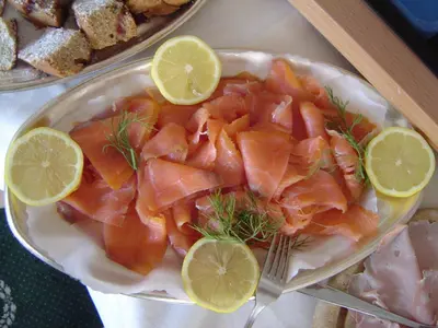 a plate of food with salmon and lemon slices at Hotel Garni Hubertus in Tirolo