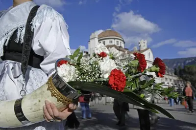 a man holding a bouquet of flowers on a street at Hotel Garni Hubertus in Tirolo