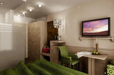 a living room with a green chair and a television at Hotel Garni Hubertus in Tirolo