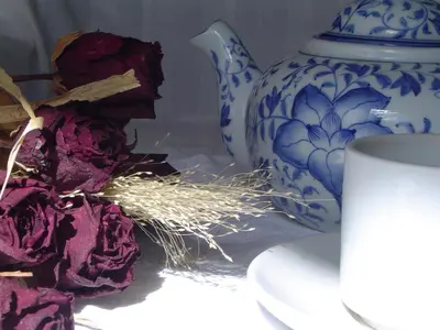 a blue and white vase and some dried flowers and a cup at Hotel Garni Hubertus in Tirolo
