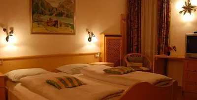 a living room with couches and a couch and a table at Albergo Genziana in San Vigilio Di Marebbe
