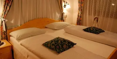 a bed with two pillows on it in a bedroom at Albergo Genziana in San Vigilio Di Marebbe