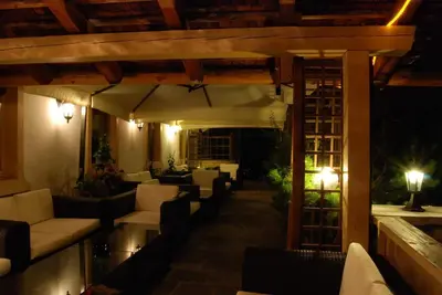 a room with three beds and a table and a television at Albergo Genziana in San Vigilio Di Marebbe