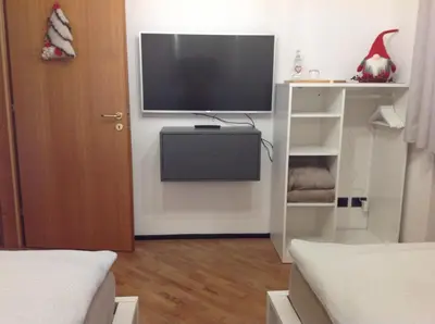 a living room with a tv and a room with a bed at VILLA ROOMS in Laives