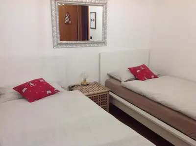 two twin beds in a room with a mirror at VILLA ROOMS in Laives
