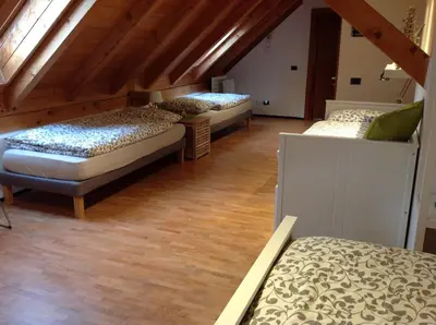 three beds in a room with wooden ceilings at VILLA ROOMS in Laives