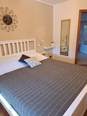 a bedroom with a bed with a blue comforter and a mirror at VILLA ROOMS in Laives