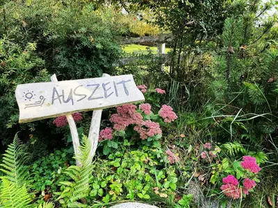 a sign in the middle of a garden with flowers at Wieshof in Laion