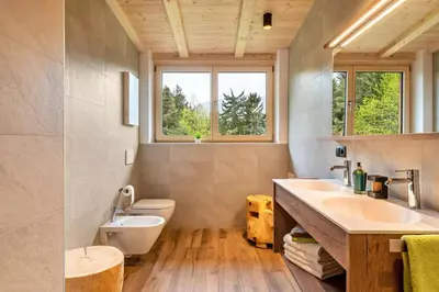 a bathroom with two sinks and a toilet and windows at Wieshof in Laion