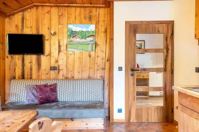a living room with a couch in a wooden wall at Wieshof in Laion