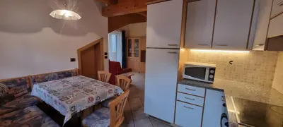 a small kitchen with a table and a microwave at Casa Soraruf in Campitello di Fassa