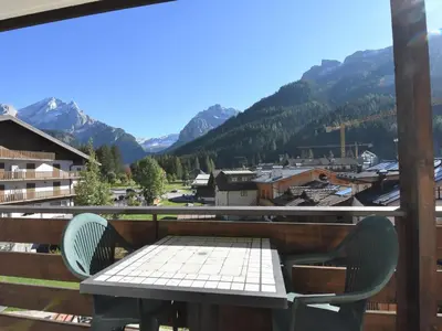 a table and chairs on a balcony with mountains at Apartment Cesa Lucilla by Interhome in Canazei