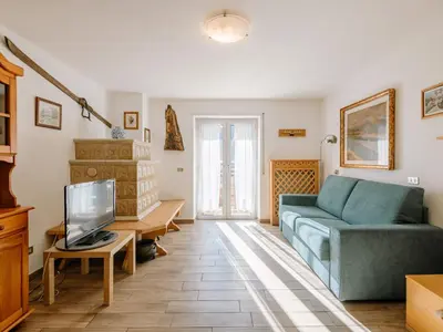a living room with a blue couch and a tv at Apartment Cesa Lucilla by Interhome in Canazei