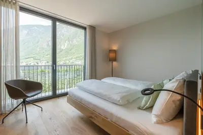 a bedroom with a bed and a large window at Feldhof Vilpian- Urlaub auf dem Bauernhof in Vilpiano