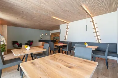 a dining room with wooden tables and chairs at Feldhof Vilpian- Urlaub auf dem Bauernhof in Vilpiano