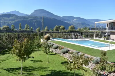 a villa with a swimming pool and mountains in the background at Feldhof Vilpian- Urlaub auf dem Bauernhof in Vilpiano