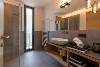 a bathroom with a sink and a glass shower at Feldhof Vilpian- Urlaub auf dem Bauernhof in Vilpiano