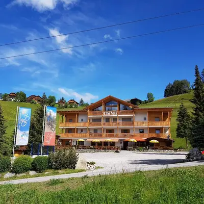 a hotel in the mountains with a building at Garni B&B Chi Vai in San Vigilio Di Marebbe