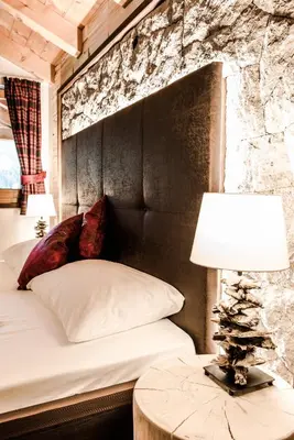 a bedroom with a bed and a table with a lamp at Garni Residence Soraiser in Selva di Val Gardena