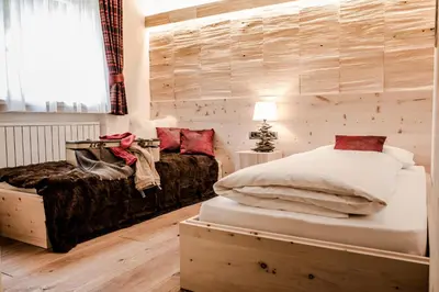a bedroom with two beds and a window at Garni Residence Soraiser in Selva di Val Gardena
