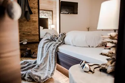 a bedroom with a bed and a mirror at Garni Residence Soraiser in Selva di Val Gardena