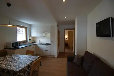 a kitchen and a living room with a couch at Residence La Planta in Ortisei