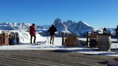 two people walking a dog on a snow covered mountain at Residence La Planta in Ortisei