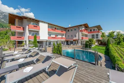 an apartment with a swimming pool and patio furniture at B&B Garni Erika in Termeno