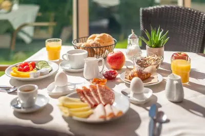 a table with plates of breakfast food on it at B&B Garni Erika in Termeno