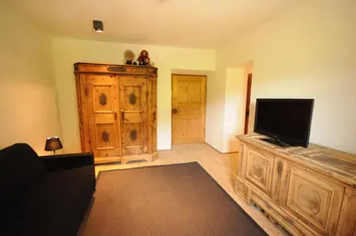 a living room with a television on a wooden entertainment center at Steinwandterhof in Braies