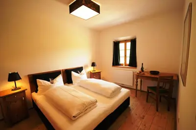 a bedroom with a bed with white sheets and a window at Steinwandterhof in Braies