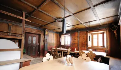 a dining room with wooden walls and tables and chairs at Steinwandterhof in Braies