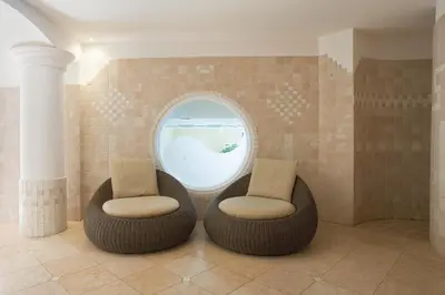 two chairs sitting in a room with an oval window at Frida am Wald in Rasùn di Sotto