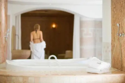 a woman standing in front of a tub in a bathroom at Frida am Wald in Rasùn di Sotto