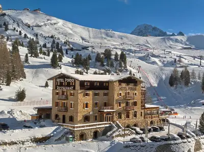 a large building in the snow on a mountain at Hotel Pordoi Passo Pordoi Vegetarian Hotel in Canazei
