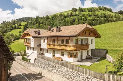 a house on a hill with a fence at App. Désirée in San Vigilio Di Marebbe