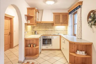 a kitchen with wooden cabinets and a sink at App. Désirée in San Vigilio Di Marebbe