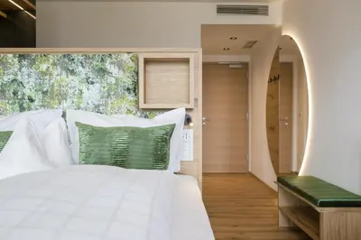 a bedroom with a white bed with green pillows at Pension Grafenau in Schenna