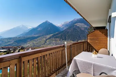 a balcony with a table and a view of mountains at Pension Grafenau in Schenna