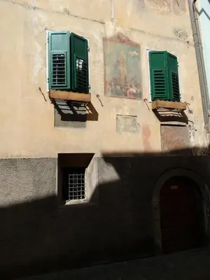 a building with green shutters and a window at Casa Volcan in Tesero